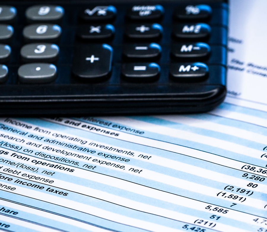 Bottom of calculator on top of financial papers.